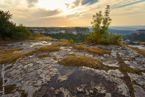 Plateau in the mountains. After the rain. Rainy puddles on a plateau. On the top of the mountain. Smooth surface. On the Sunset. The backdrop of the setting sun and the surface of the mountain.