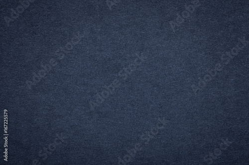 Texture of old navy blue paper background, closeup. Structure of dense dark denim cardboard