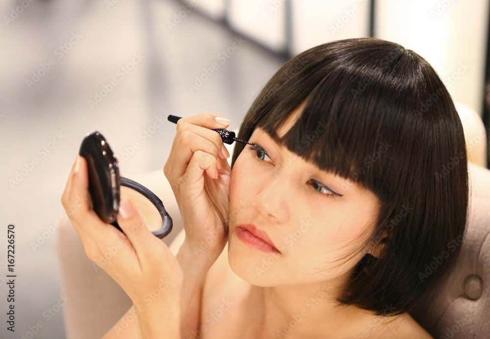 Fototapeta premium Beautiful young woman using a makeup.