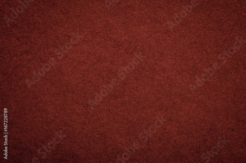 Texture of old dark red paper background, closeup. Structure of dense maroon cardboard