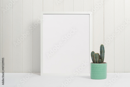White picture frame on white background with cactus plant