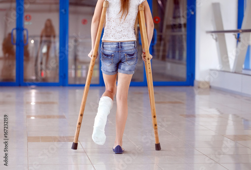 A young girl is on crutches in the corridor of the hospital.