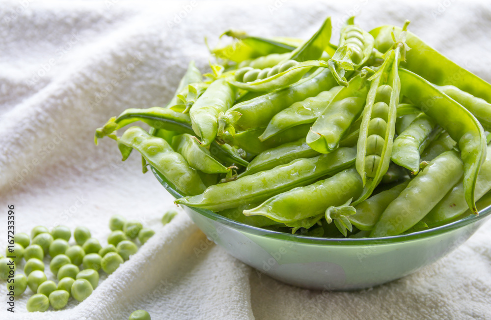 Green peas. Hulk pods in a glass bowl