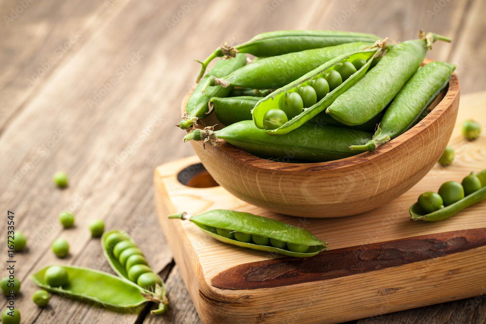 Ripe peas in a wooden bowl on wooden table Ripe peas in a wooden bowl on wooden table