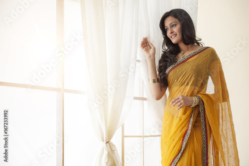Tableau sur toile Woman in a saree looking out a window