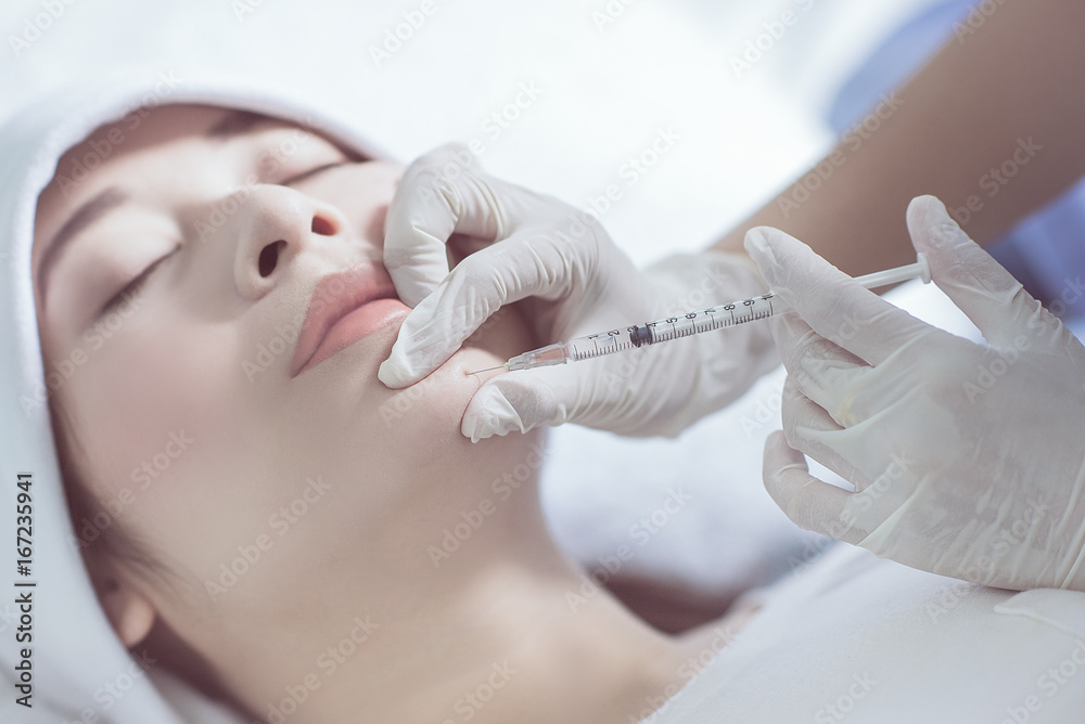 Doctor hands are injecting liquid, Into the ridge under the eyes.