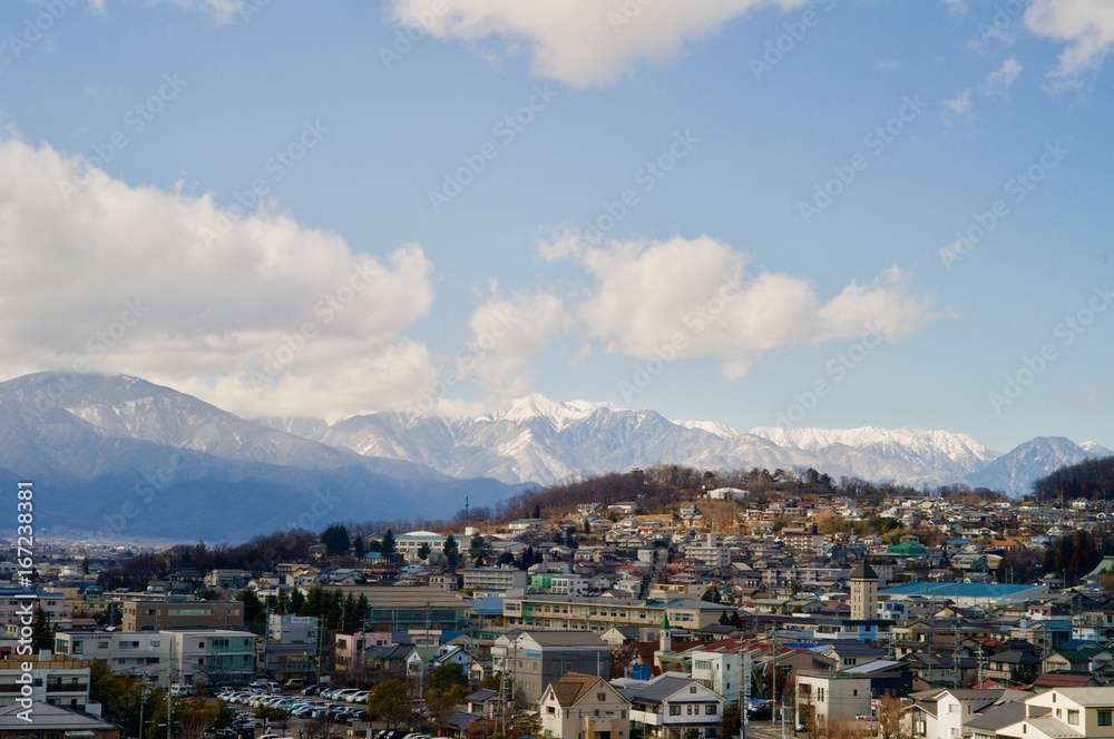 北アルプスの山々を背景にする住宅街