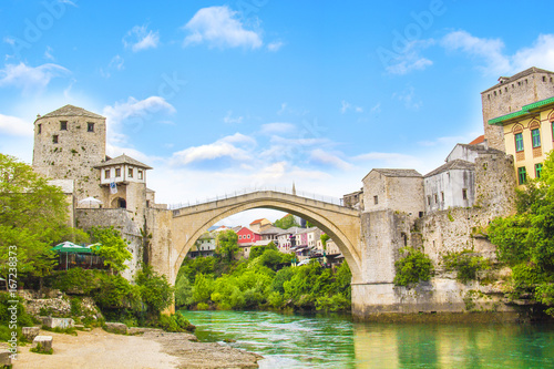 A beautiful view of the old bridge across the Neretva River in Mostar, Bosnia and Herzegovina, on a sunny summer day © marinadatsenko
