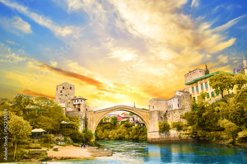 A beautiful view of the old bridge across the Neretva River in Mostar, Bosnia and Herzegovina, on a sunset photo