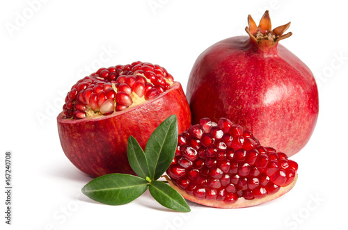 one whole and part of a pomegranate and leaves isolated on white background