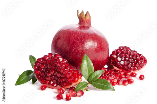 one whole and part of a pomegranate with pomegranate seeds and leaves isolated on white background