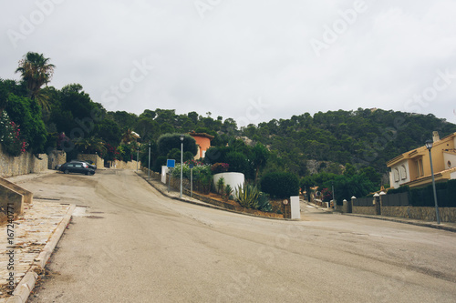 lonely street at mallorca with houses and cars