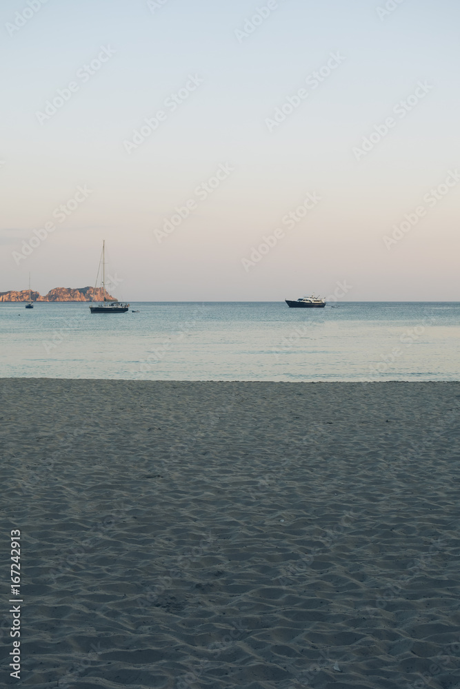 high angle format of beach in the evening with some sailing boats