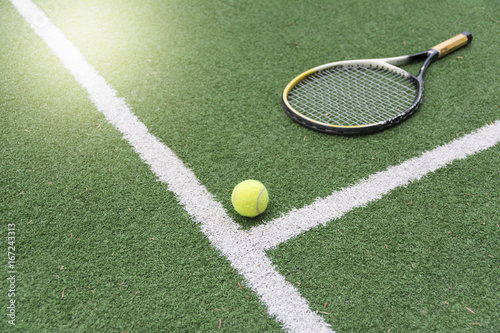 Tennis ball and racket on tennis court