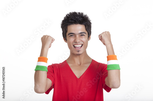 Canvas Print Portrait of happy teenage boy in red t-shirt cheering with clenched fists over w