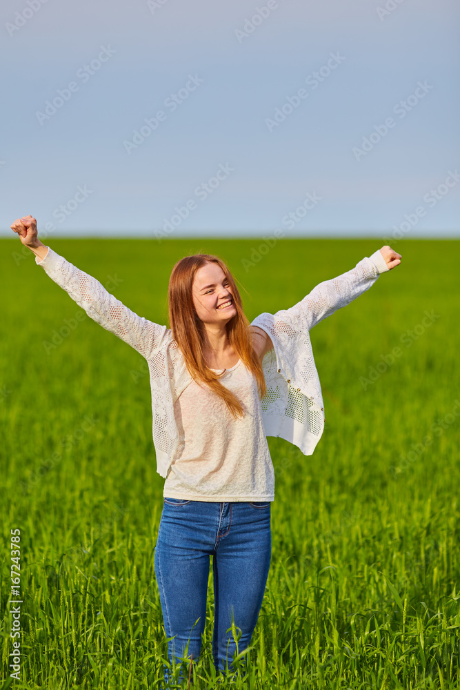 Girl with open arms on a green wheat field Girl with open arms on a green wheat field