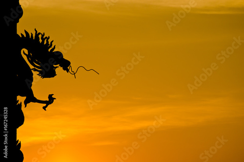 Chinese style Dragon statue silhouette with sunset.