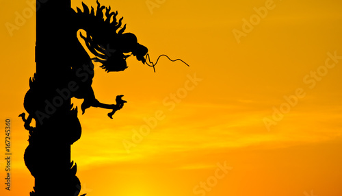 Chinese style Dragon statue silhouette with sunset. © ohmega1982
