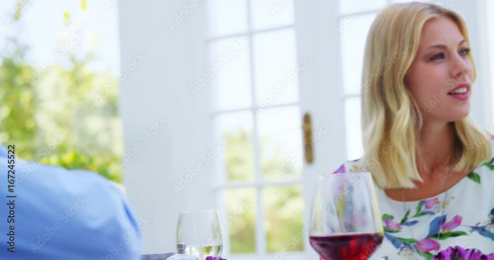Friends interacting with each other while having meal together Friends interacting with each other while having meal together
