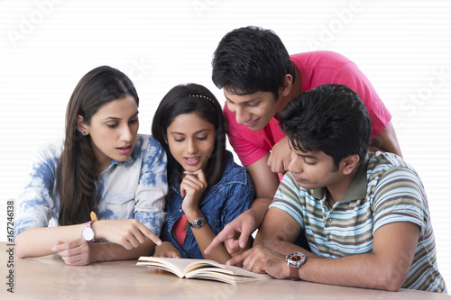 College students reading book in library
