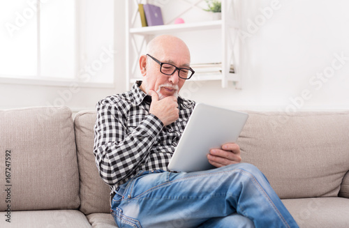 Senior man reading news on digital tablet © Prostock-studio