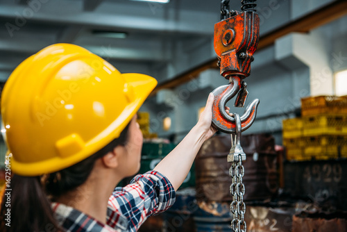 industrial factory woman holding chain crane photo