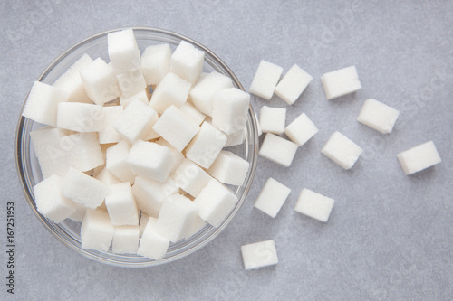 White sugar cubes on gray background from top view