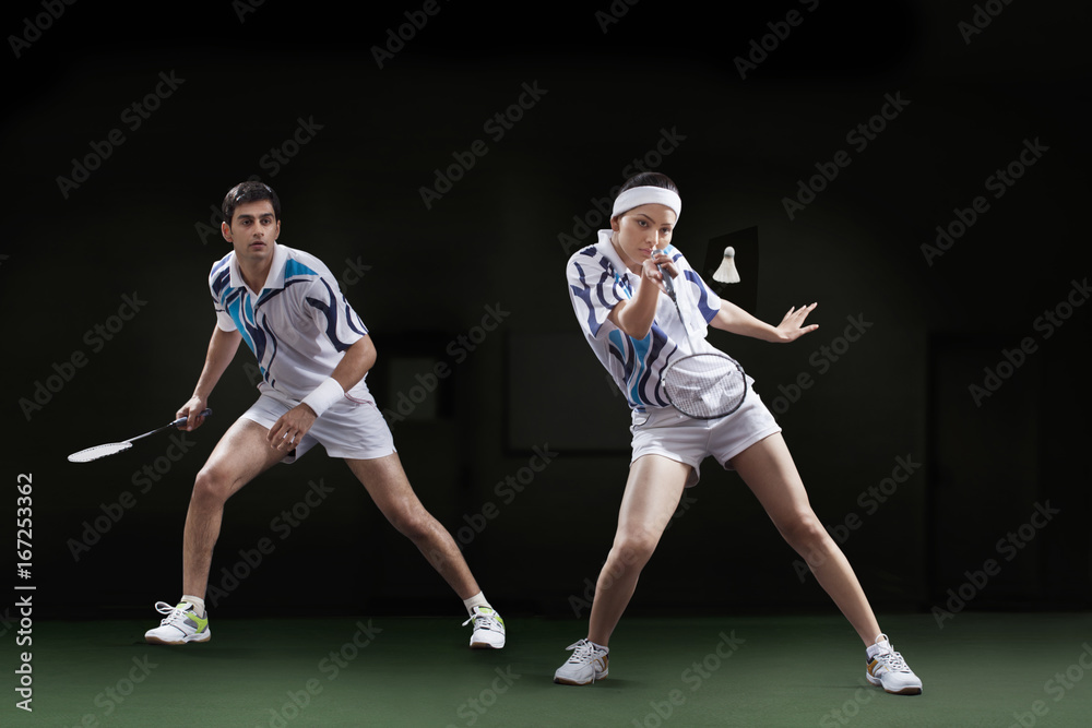 Players playing badminton doubles at court