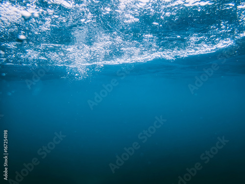 Underwater turquoise texture in ocean. Bubbles in tropical sea.  © artifirsov