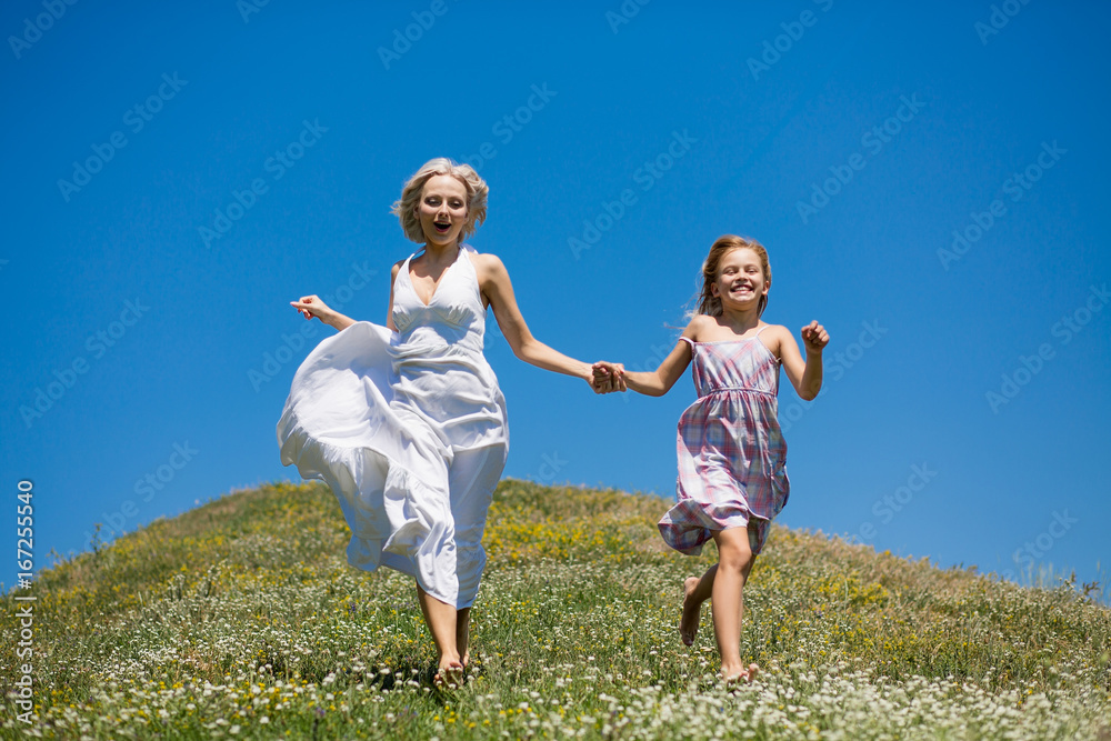 Happy childhood concept, mother and daughter holding hands, running. Young woman playing with daughter. Happy childhood concept, mother and daughter holding hands, running. Young woman playing with daughter.