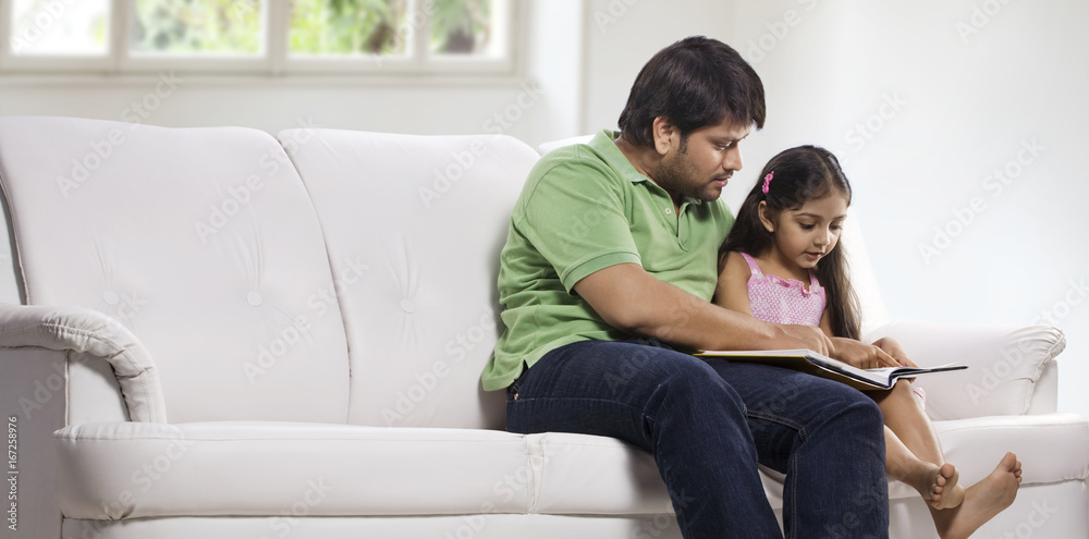 Father and daughter reading a book 