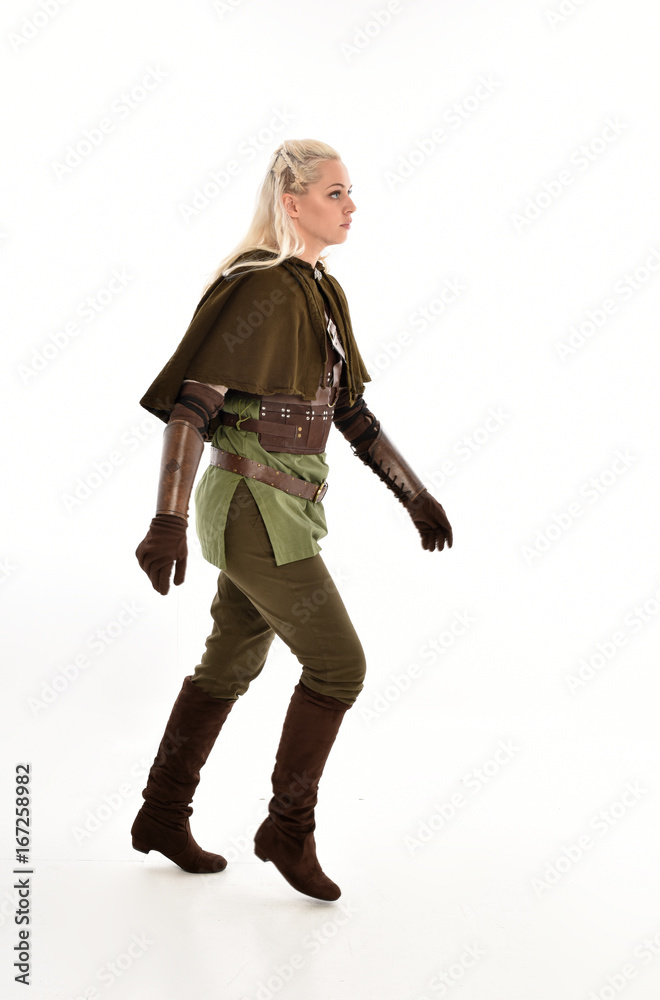 full length portrait of a blonde girl wearing green and brown medieval costume, holding a bow and arrow. isolated on white background. full length portrait of a blonde girl wearing green and brown medieval costume, holding a bow and arrow. isolated on white background.