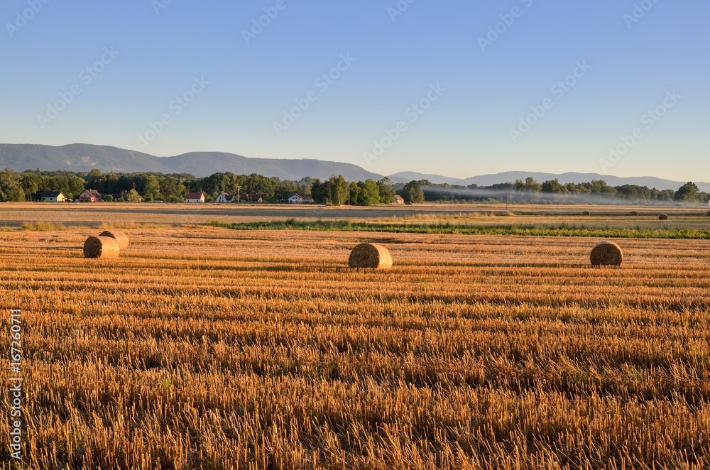 Summer rural landscape. Haystack in a meadow with mountain landscape. Summer rural landscape. Haystack in a meadow with mountain landscape.