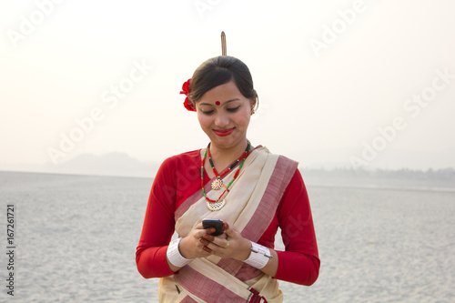 Bihu woman reading an sms on a mobile phone  photo