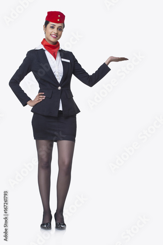 Portrait of an airhostess holding invisible product isolated over white background 