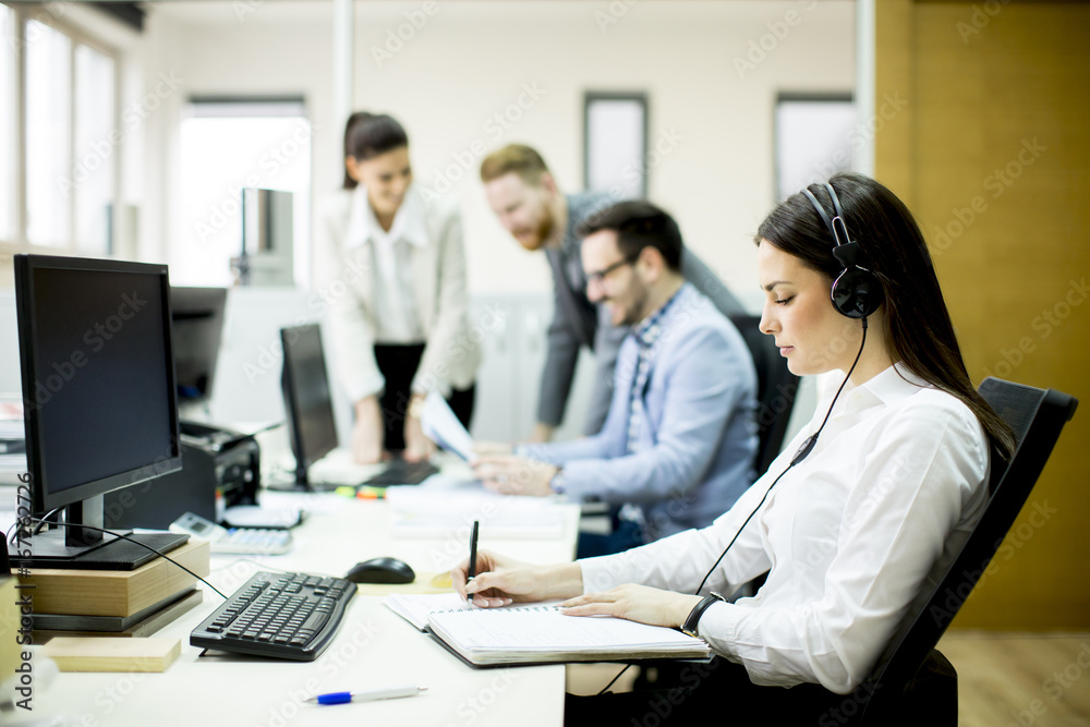 Team of young colleagues working together in an office Team of young colleagues working together in an office