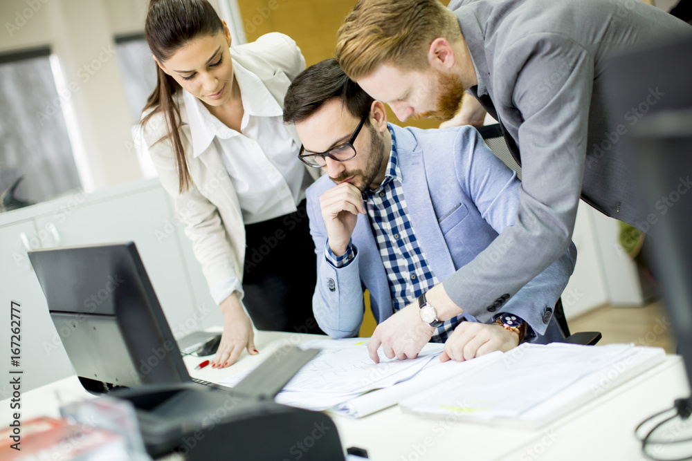Team of young colleagues working together in an office Team of young colleagues working together in an office