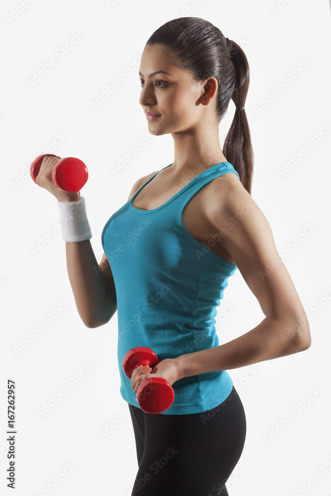 Young woman in sportswear exercising against white background Young woman in sportswear exercising against white background