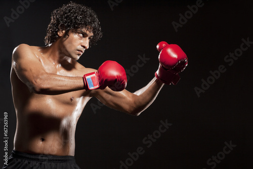 Young man wearing boxing gloves  © IndiaPix