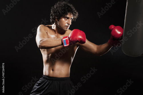 Young male boxer punching the bag  © IndiaPix