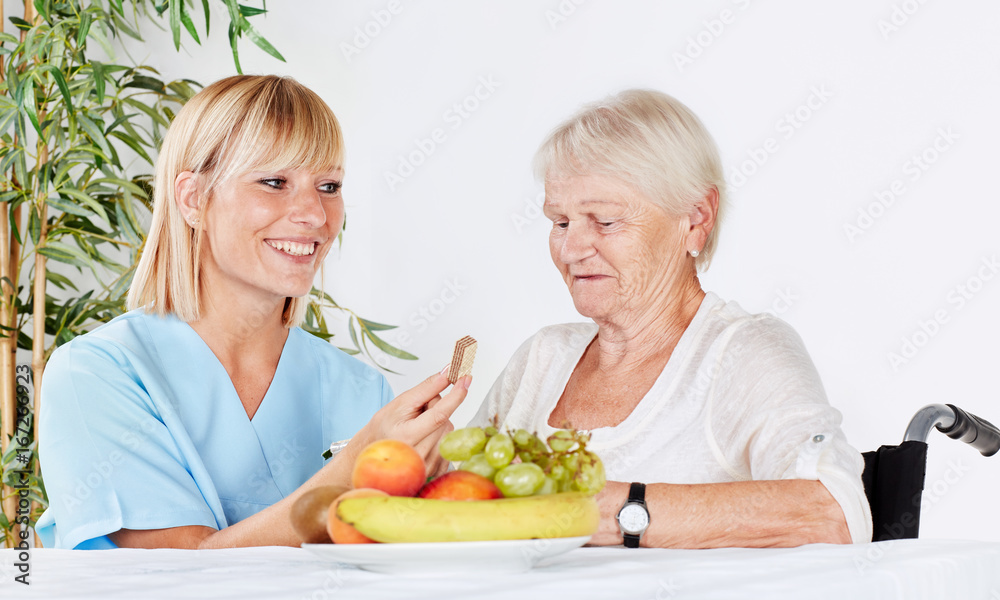 Carer feeds a elderly person