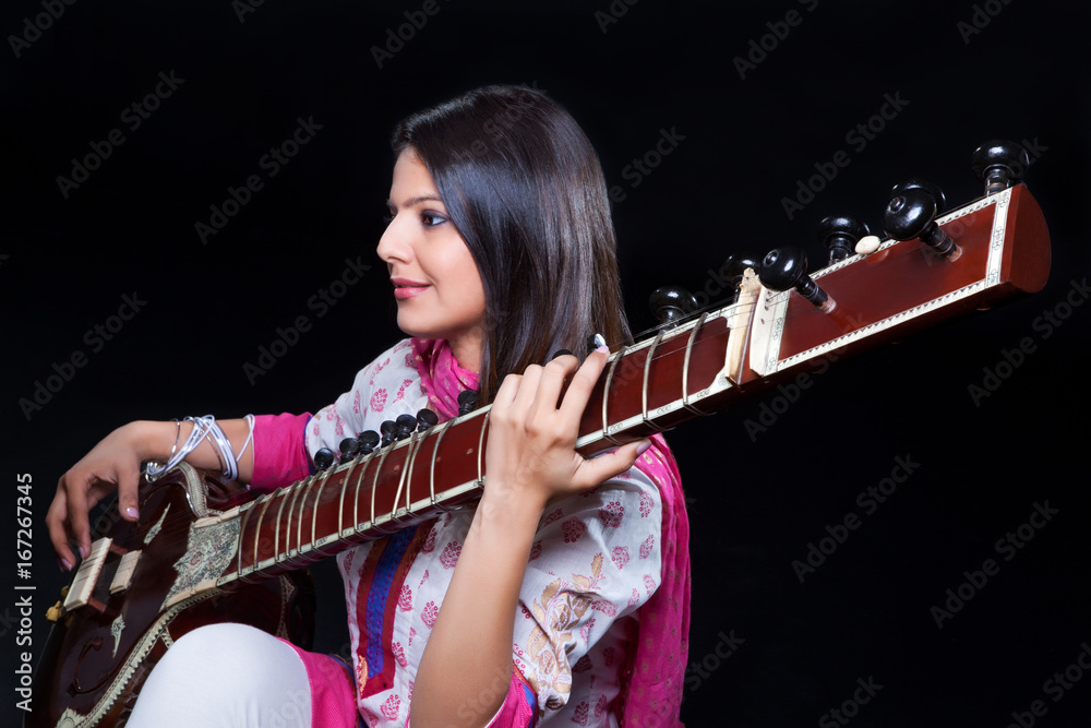 Obraz premium Young woman playing the sitar