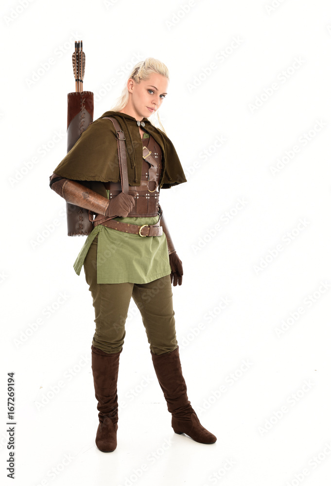 full length portrait of a blonde girl wearing green and brown medieval costume, holding a bow and arrow. isolated on white background. full length portrait of a blonde girl wearing green and brown medieval costume, holding a bow and arrow. isolated on white background.