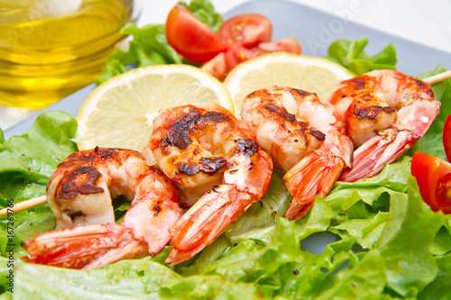 plate of grilled prawns with salad and cherry tomatoes