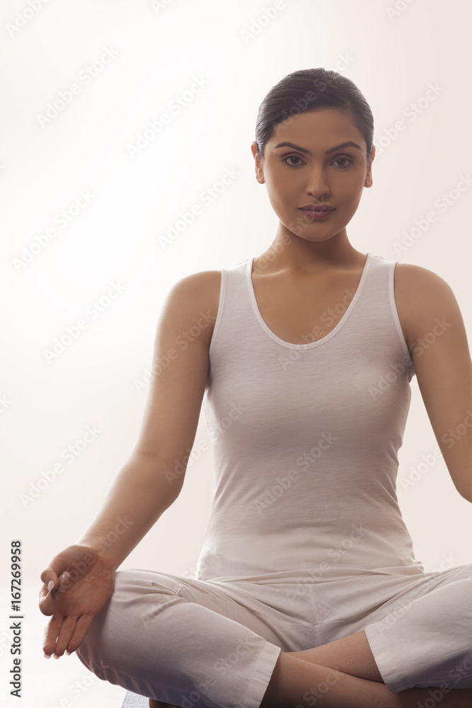 Portrait of young woman sitting in lotus position Portrait of young woman sitting in lotus position