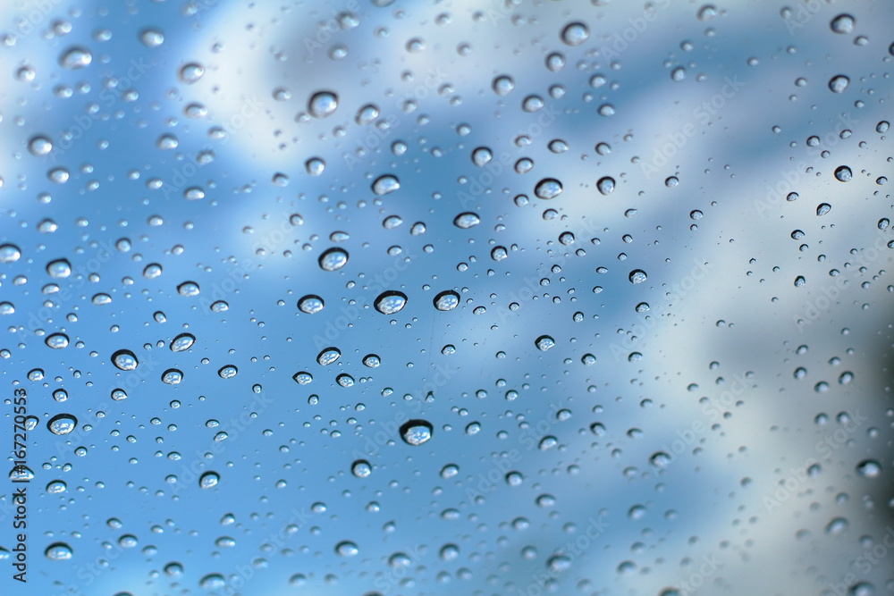 Raindrops on the glass against the blue sky