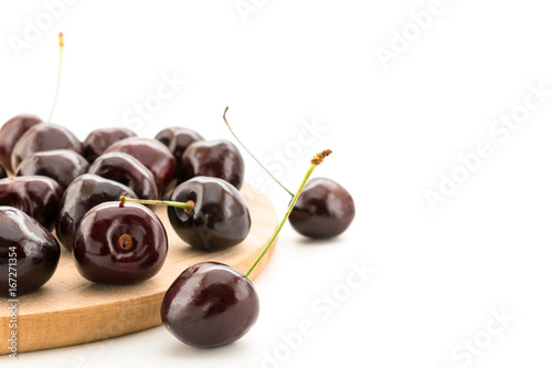 ripe cherries on a wooden butcher closeup on a white