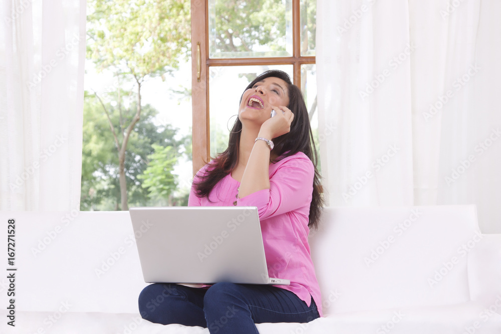 Woman laughing while talking on mobile phone Woman laughing while talking on mobile phone