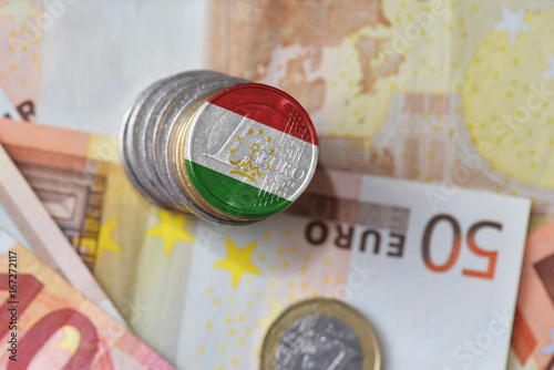 euro coin with national flag of tajikistan on the euro money banknotes background.