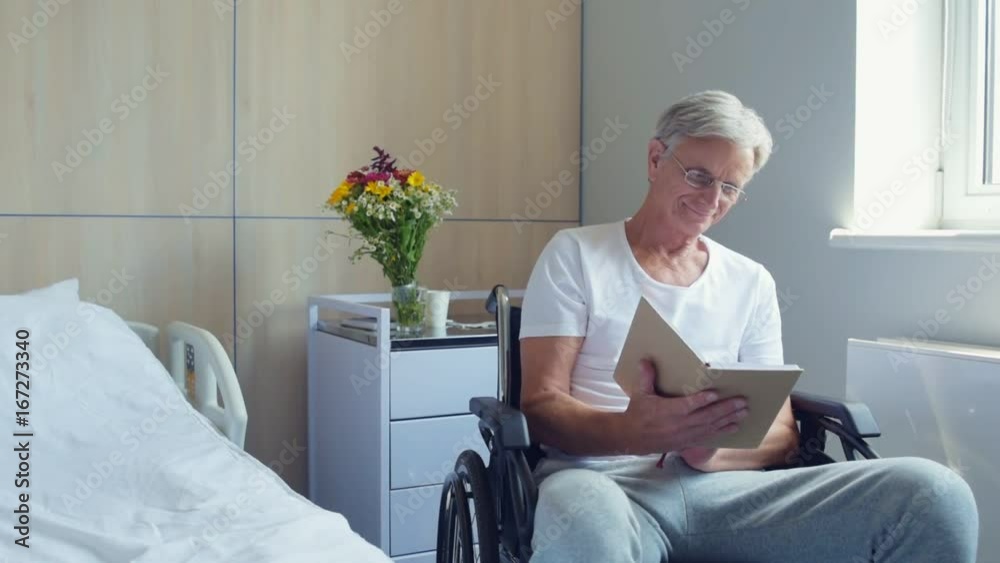 Nice aged man reading book in a hospital ward
